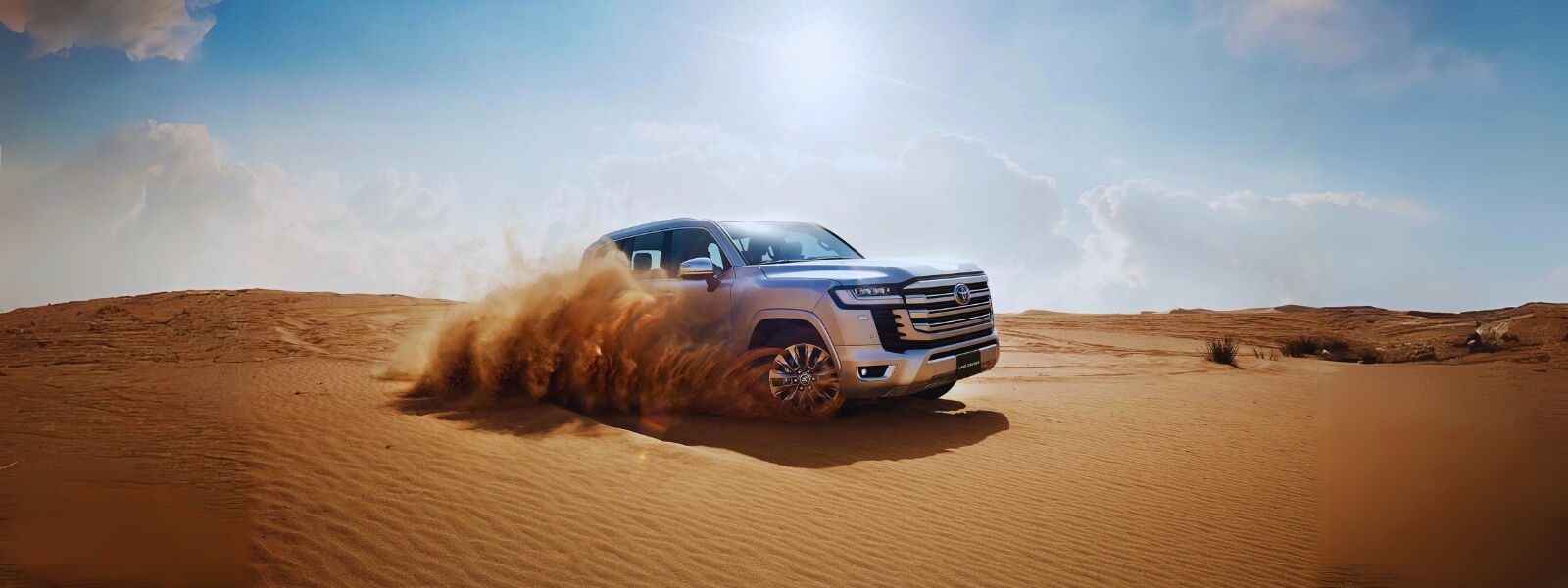 An SUV driving through the desert under a clear blue sky on a sunny day.
