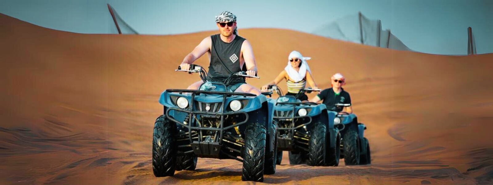 Group of individuals enjoying a desert adventure on ATV bikes.