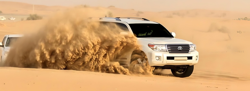 A white SUV driving through the desert, showcasing the vastness and solitude of the arid landscape.