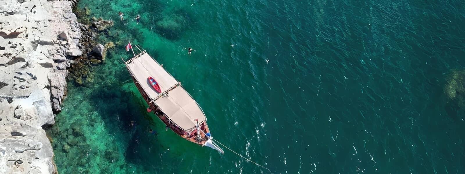 A sailboat sailing in the vast ocean, viewed from above.