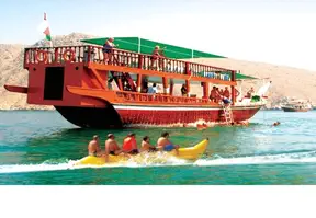 A boat with many people on it sailing in the water.