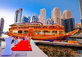 A dhow docked in front of a city skyline, showcasing the harmonious blend of urban and maritime elements.