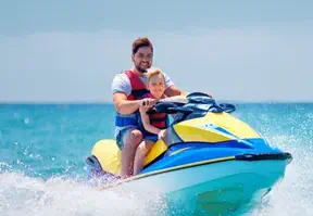 Man and child enjoying a ride on a jet ski.
